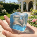 Squishy cubo de hielo azul transparente sostenido en una mano